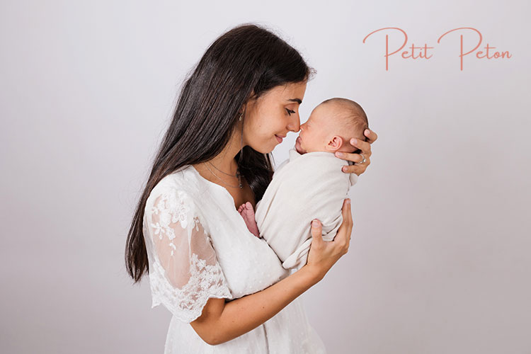 Maman câlinant son bébé pendant une séance photo naissance près de Paris.