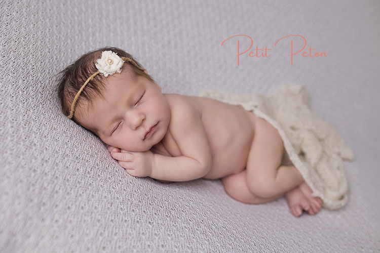 Nouveau-né endormi paisiblement lors d'une séance photo au studio Petit Peton à Cachan.